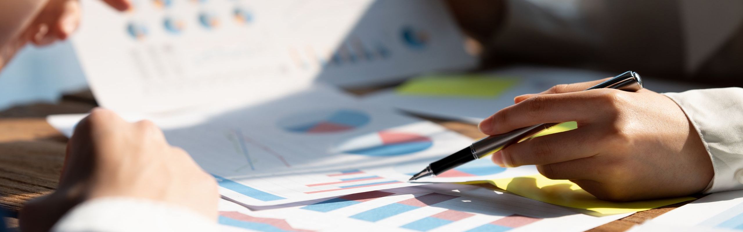 foto di due persone che si confrontano guardando dei grafici stampati
