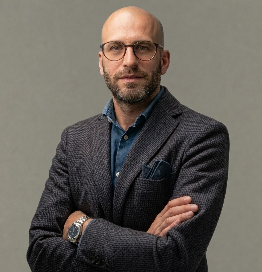 Foto a mezzo busto di Carlo Apostoli giacca Grigia, camicia blu, sfondo grigio
